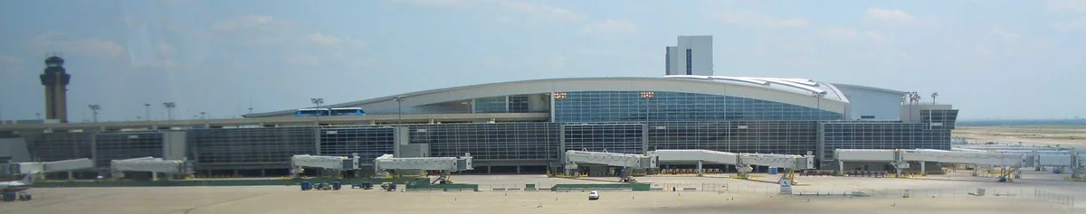 Panoramic exterior view of DFW Airport Terminal D from Terminal B.
