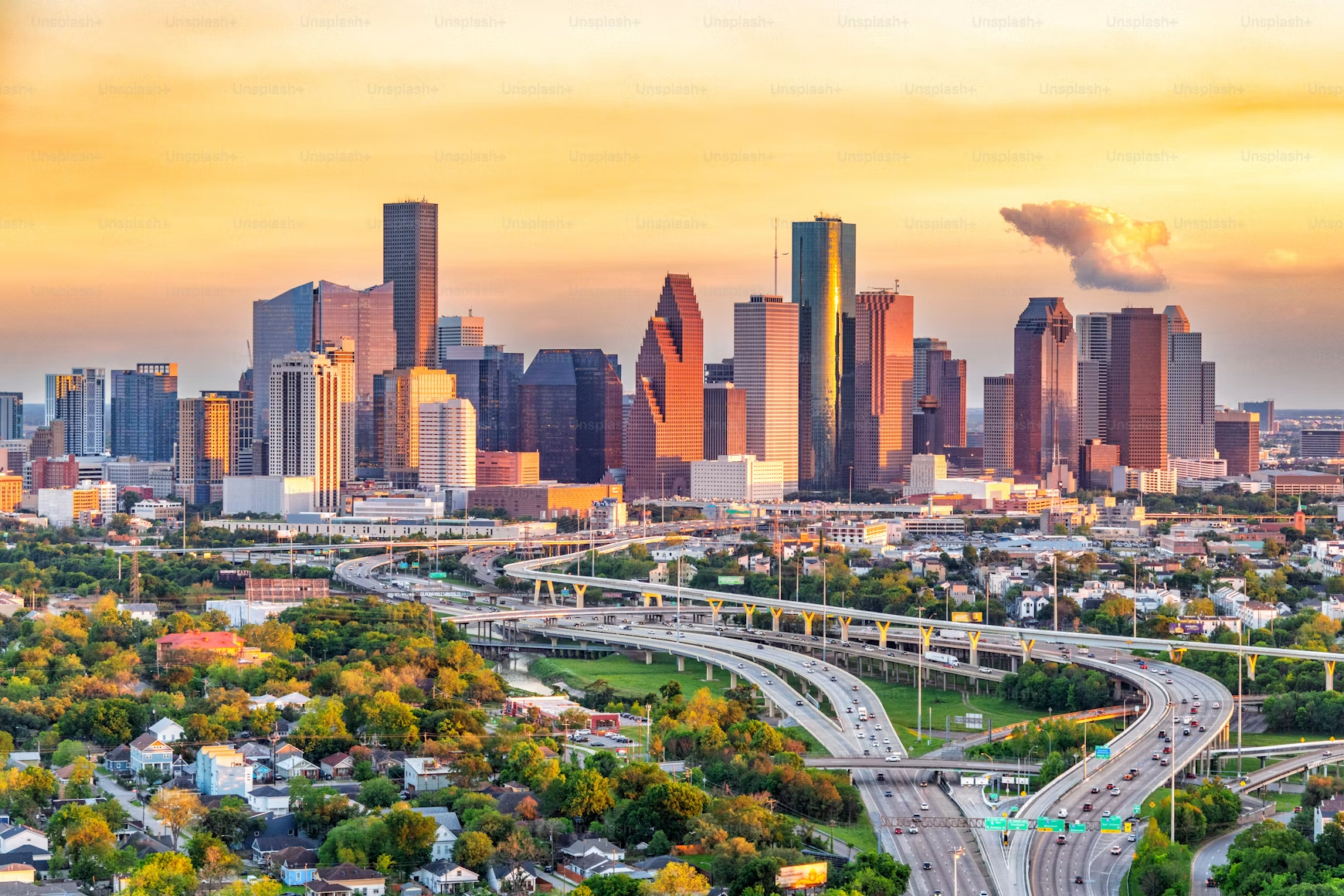 Downtown Houston skyline and freeway interchange at sunset.